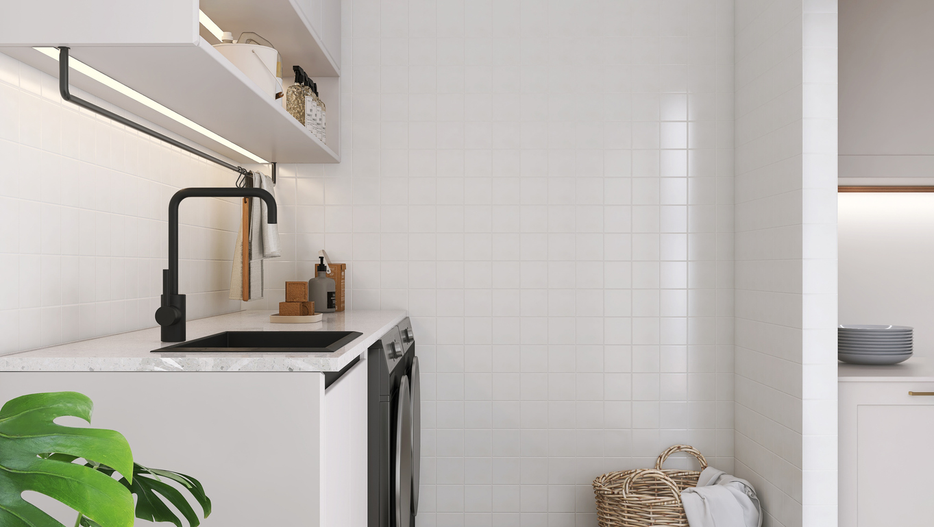 White square tile wall in modern and minimal laundry room with terrazzo countertop, black quartz sink and faucet, washing machine and dryer in sunlight for luxury cleaning and washing product display, interior design decoration background