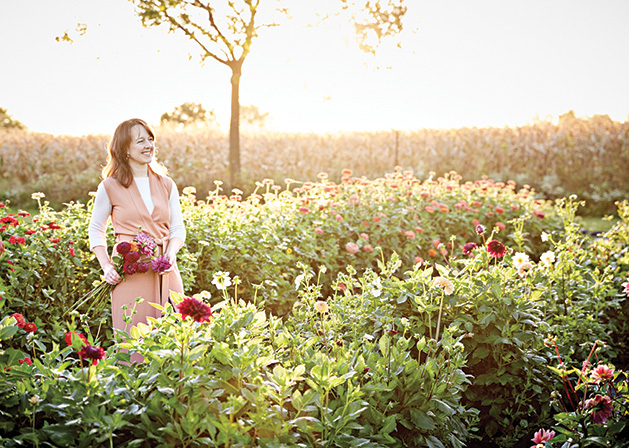 Floral designer Ashley Fox stands in a field of flowers.