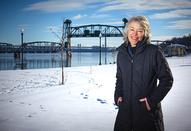 Charlene Roise, author of The Saga of the Stillwater Lift Bridge, stands with the bridge in the background.