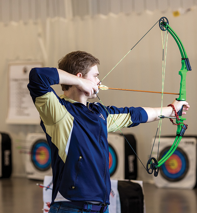 A student on the St. Croix Preparatory Academy archery team pulls back for a shot.
