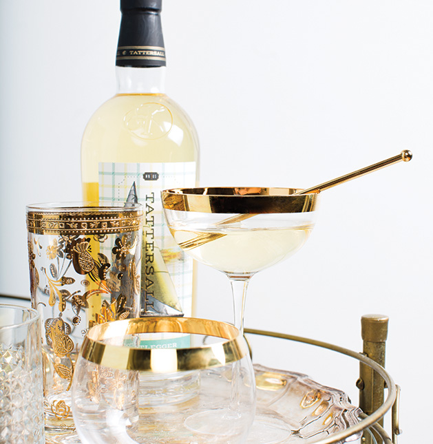 A bottle of liquor from Tattersall Distilling sits on a bar cart with an aperitif.