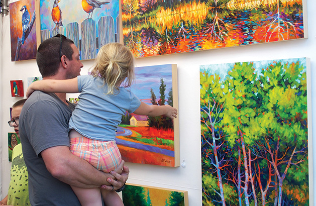 A father and daughter admire art at the Spirit of the St. Croix Art Festival, one of many local fall art festivals.