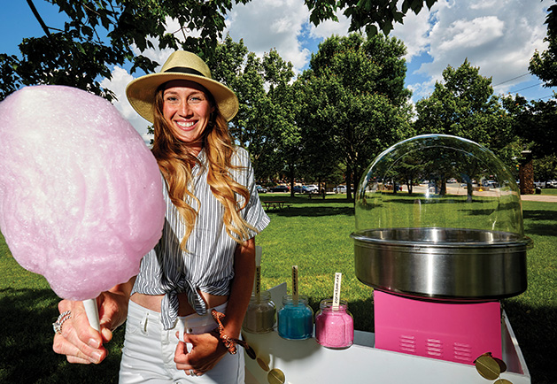 Sarah Kubler, founder of Confection Cotton Candy, stands by a cotton candy cart, available for events in Wisconsin and Minnesota.