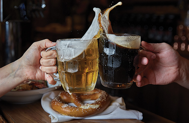 Two drinkers clink two glasses of the best local Oktoberfest beers.