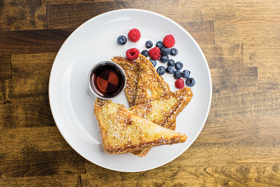 The classic French Toast is two slices of brioche, served with berries and maple syrup.