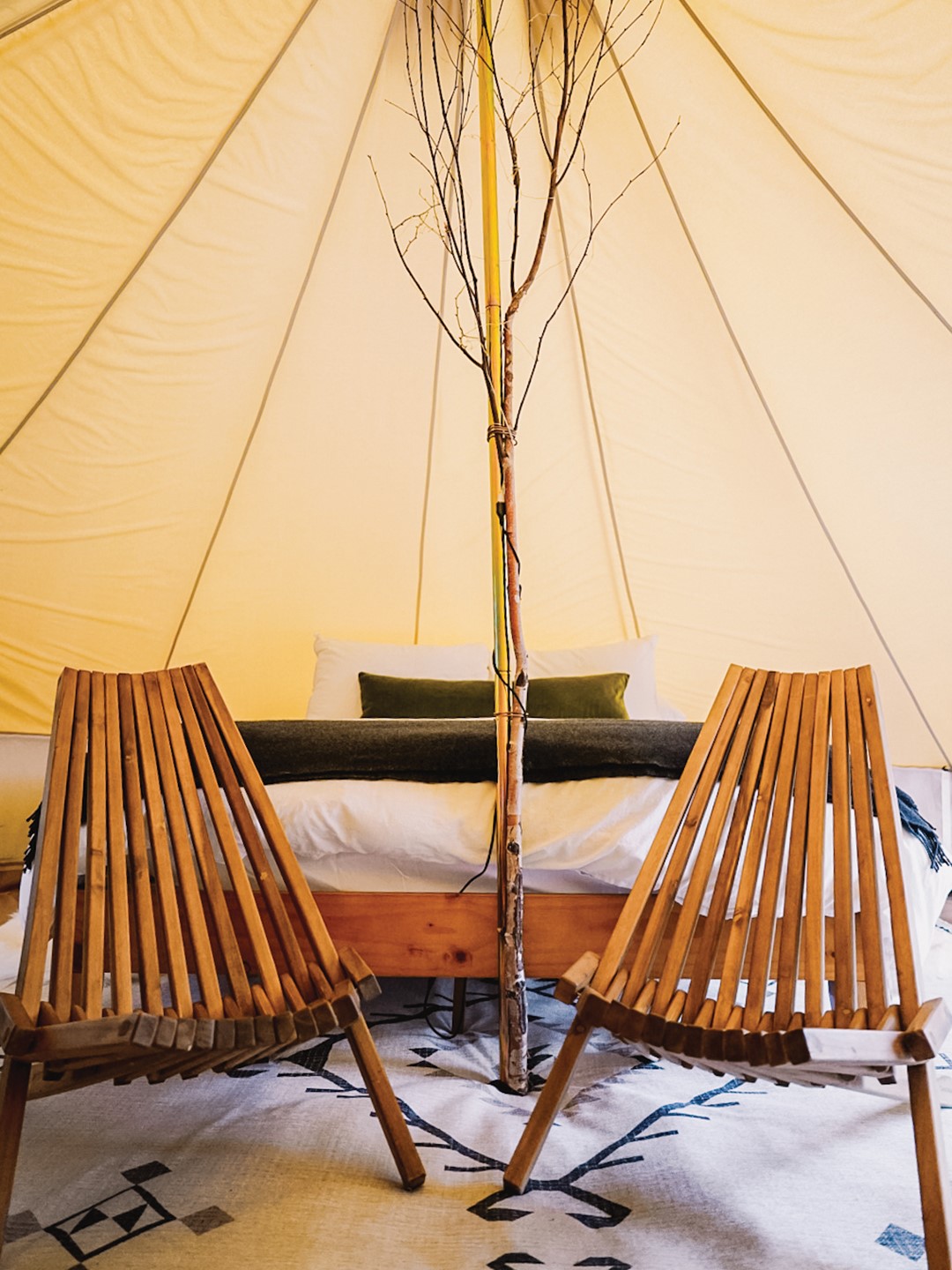 Adirondack chairs adorn the Wilder Bell Tent, set near a small wood stove. Photo: Rana Monet
