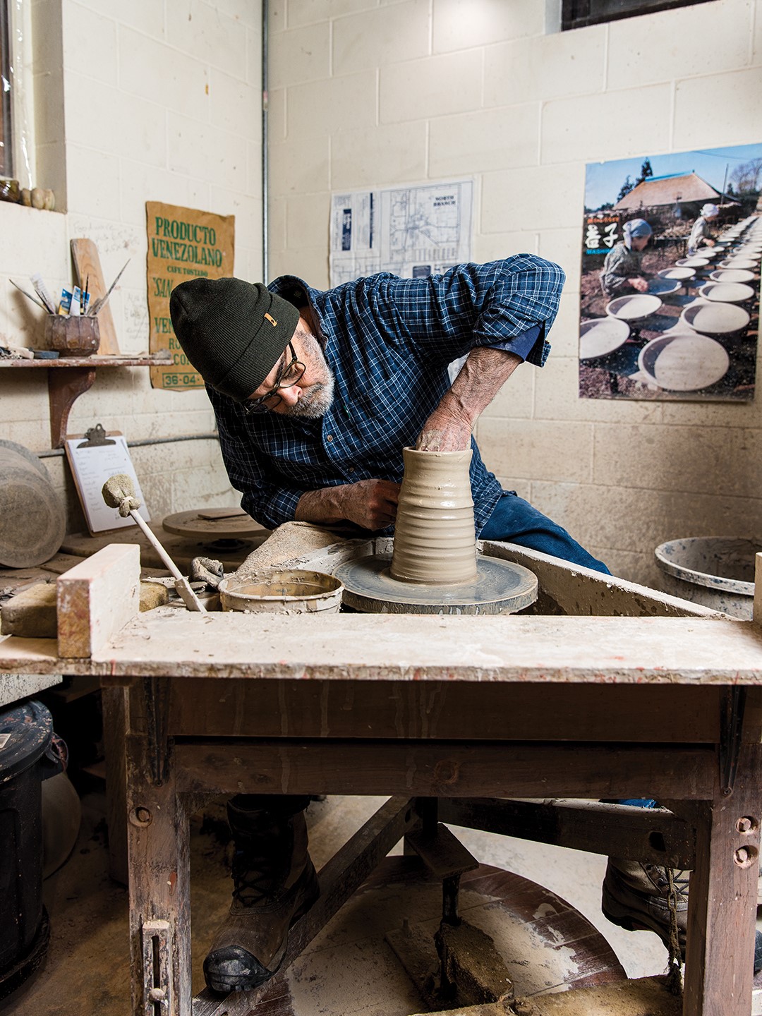 Guillermo Cuellar shapes a pot on a kick wheel at his Shafer studio. 