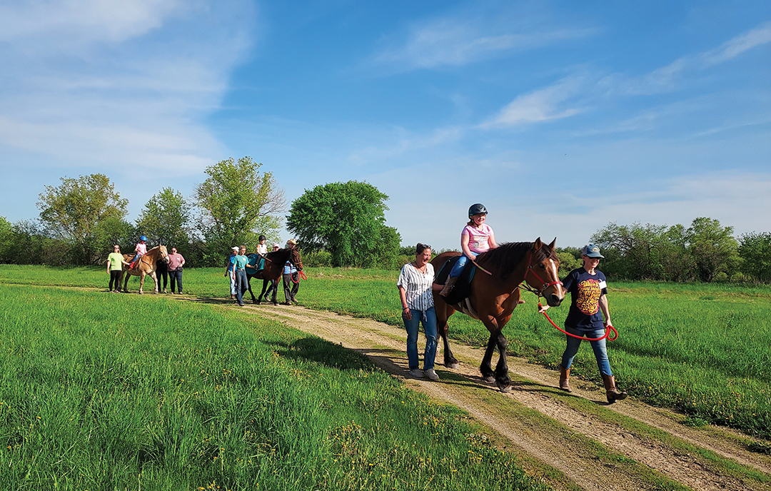 Thereputic horse-back riding program participants enjoy a stroll in the sun.