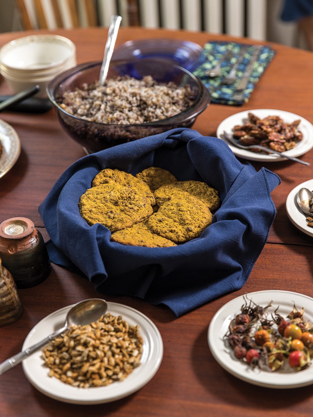 Clockwise from right: Wild Rice with Hazelnuts and Dried Blueberries; Toasted Pecans Candied with Maple Sugar; Dried Rosehips; Toasted Sunflower Seeds Candied with Maple Sugar; and Squash Biscuits with Acorn Flour.