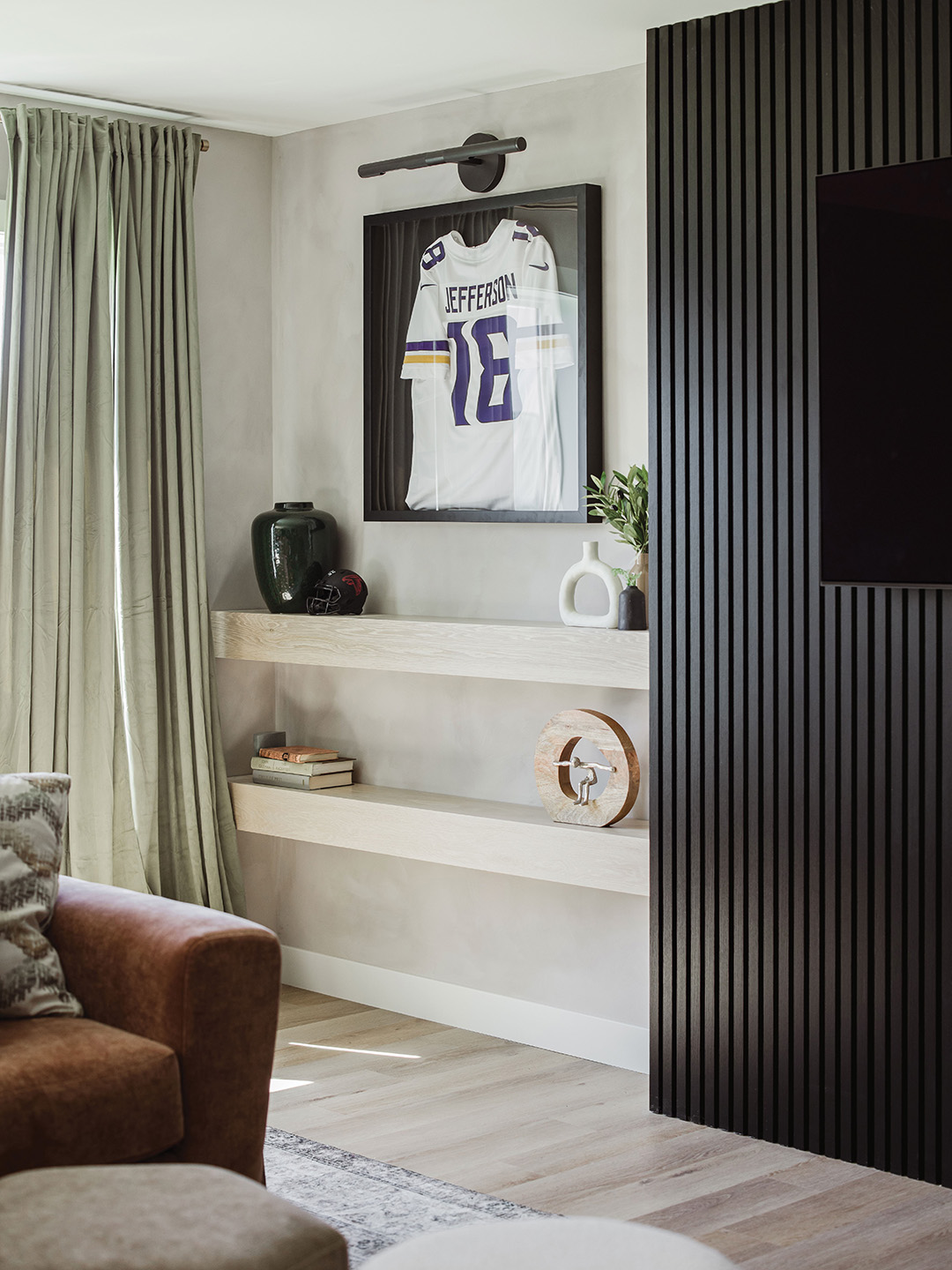 Framed jerseys in the entertainment area add a personal touch to the space, achieving the “sports bar” energy the homeowners were looking for. 