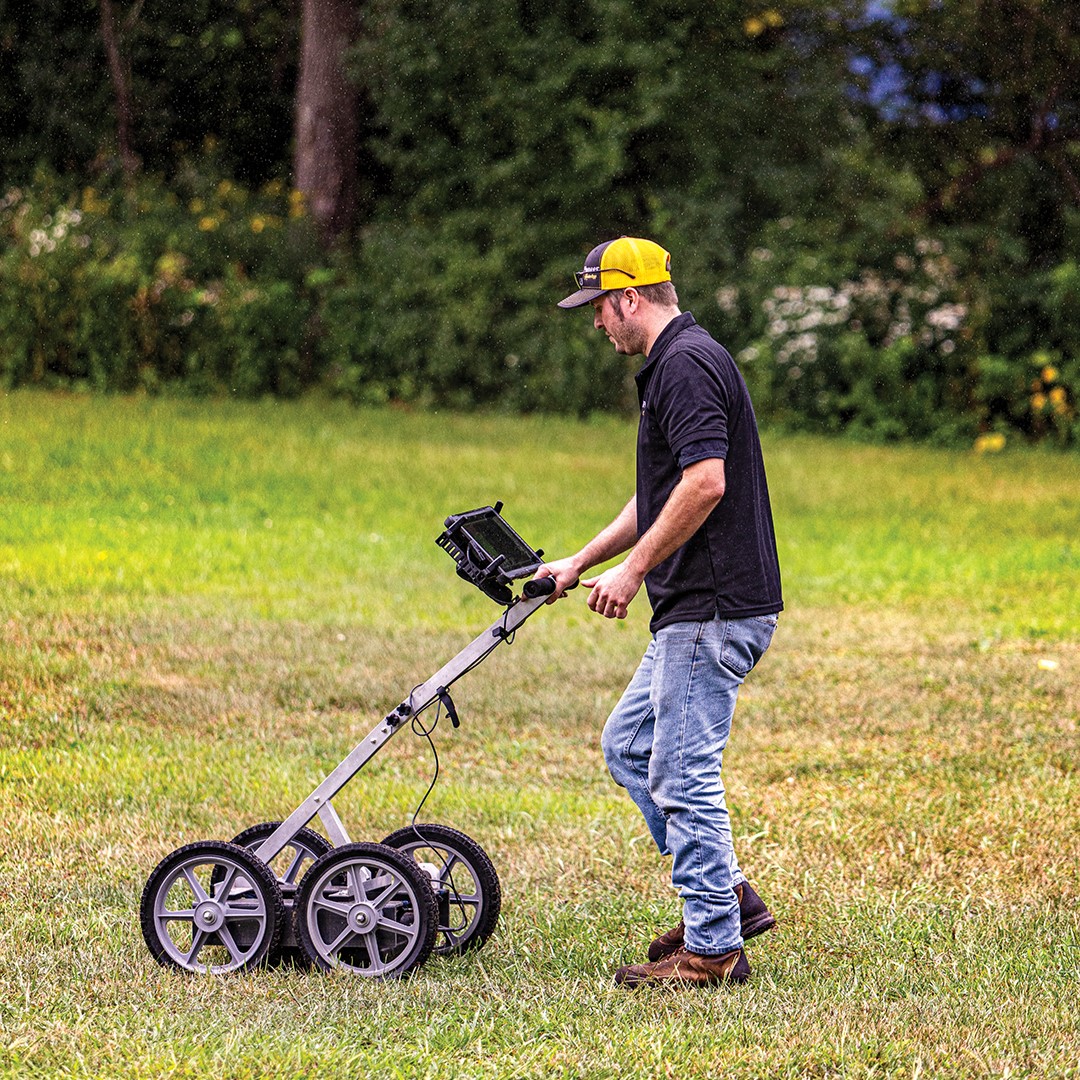 Brandon Lewanski uses a ground-penetrating radar (GPR) system by Easy Radar U.S.A. to locate potential dig sites through non-destructive radio waves.