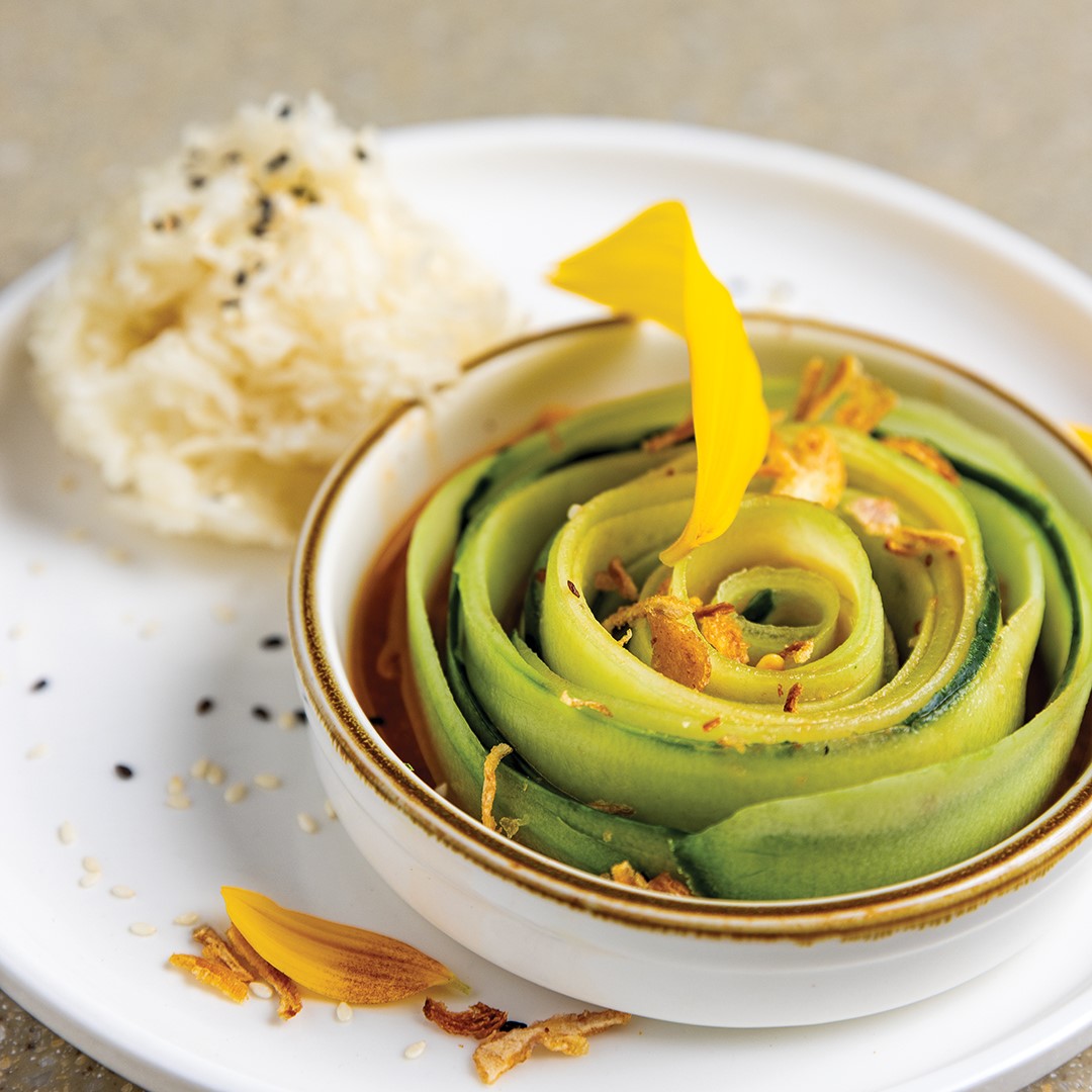 The Cucumber Salad features locally grown cucumber swirled in a soy-chili dressing, served with sticky rice and topped with black sesame seeds.